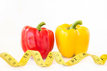 Yellow tape measure and sweet pepper on white background