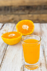 Glass of freshly pressed orange juice on wooden table