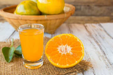 Obraz na płótnie Canvas Glass of freshly pressed orange juice on wooden table