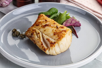 Roasted cod fish steak with salad