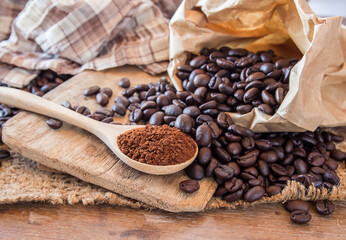 Coffee powder in wooden spoon on wooden table background