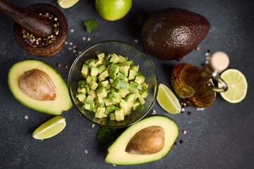 Chopped avocado in glass bowl and avocado Halves