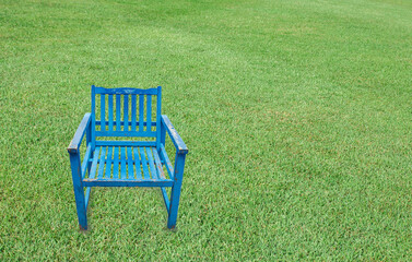 Antique blue wooden chair on a green grass background
