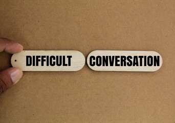 wood with the word DIFFICULT CONVERSATION. difficult conversation concepts
