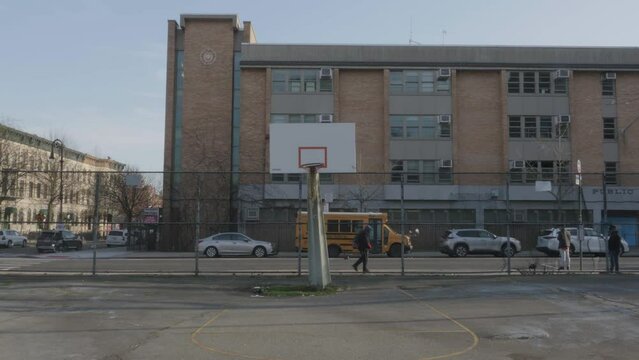 Handheld shot of a run-down basketball court in Brooklyn.