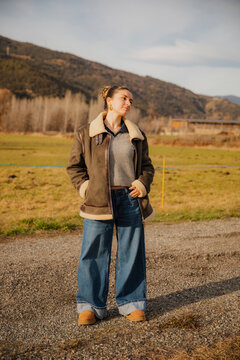 Girl in Jacket and Wide Pants in Mountains looking away