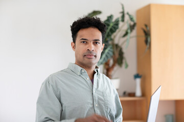 Young man, mixed race, with laptop in an office