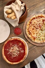 Homemade pizza breaksticks in wood bowl half pizza deep dish pizza