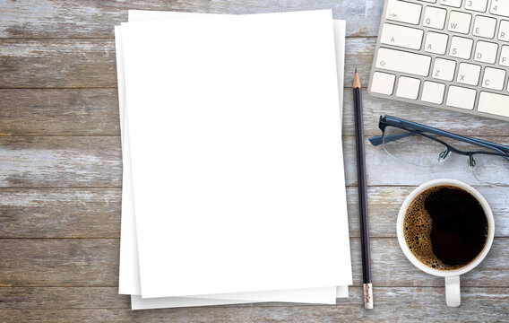 White paper or notepad with pencil and mini keyboard,cofee on wood table background.using wallpaper for education, business photo.