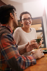 Couple, date and coffee shop with funny joke and talking together with hot drink in a cafe. Woman, smile and happy from discussion and chat in a restaurant with tea or cappuccino at a table