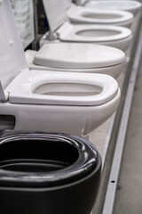 A row of grey automotive toilets are lined up in a store resembling automotive design elements such...