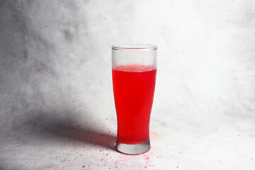 Glass of strawberry syrup isolated on white background.