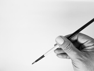 hand holding a brush in black and white