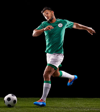 Man, ball and soccer for sport and fitness for game, active and sportswear on grass or field. Role model, athlete or player and practice for kick, competitive and score in night on dark background