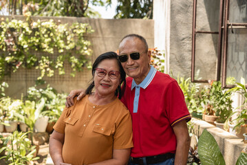Affectionate Asian senior couple enjoying a sunny day in their garden
