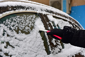 Removing snow from car windshield. Clean car window in winter from snow. - 765433065