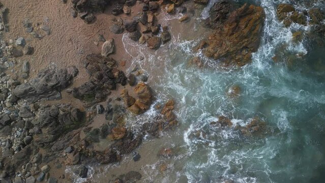Drone shot of the Atlantic Ocean waves crashing on rocks on Matosinhos Beach in Porto city, Portugal