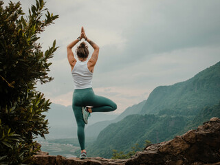 A Woman Embraces Yoga and Achieves Serenity in Tree Pose, her Fit Body Harmonizing with the...