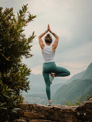 A Woman Embraces Yoga and Achieves Serenity in Tree Pose, her Fit Body Harmonizing with the...