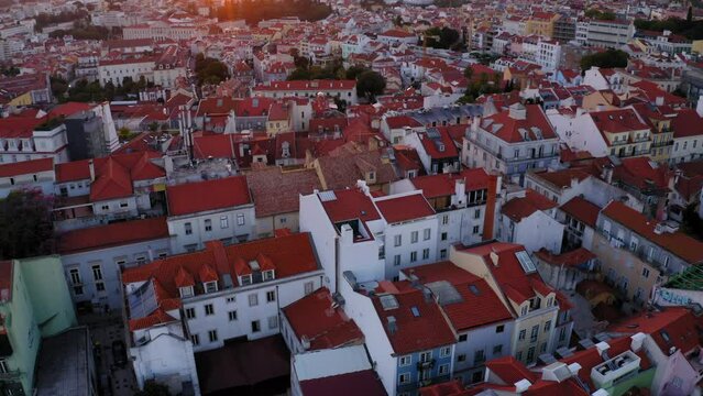Aerial Tilt Up Scenic View Of Roofed Houses In City Against Clear Sky, Drone Flying Backwards At Sunset - Lisbon, Portugal