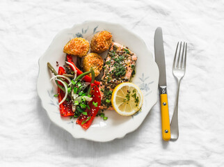 Delicious lunch - salmon baked with pesto sauce and vegetables, parmesan bread crumbs baked baby potatoes on a light background, top view