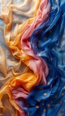 Image shows a luxurious, flowing fabric with a gradient from yellow to blue, adorned with stars