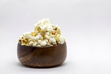 Closeup of Popcorn in a Wooden Bowl Isolated on White Background with Copy Space