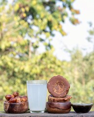 Date Palm Jaggery in Bowls or Phoenix Dactylifera Fruit, Date Palm Tree Juice in a Glass Isolated on Wooden Table with Copy Space