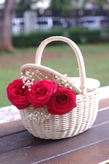 Fototapeta na wymiar Red roses arranged in a rattan basket