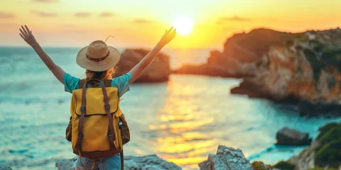 Foto auf Glas Confident woman with backpack with arms up relaxing at sunset seaside during a trip , traveler enjoying freedom in serene nature landscape, Generative AI © Focal Imaging