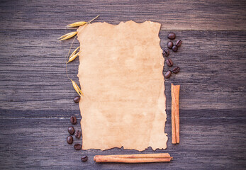 Old paper and coffee beans on dark wooden table background.