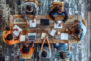 Above view of group of multi ethnic business people working in an office. Team of business people working on project in office, using laptop, writing notes at table with books, learning, Generative AI - Powered by Adobe