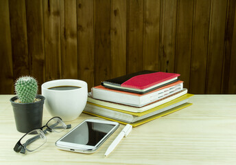 Naklejka premium Office desk table with notebooks,glasses, smart phone and a cactus
