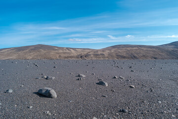 Panoramic view over Icelandic landscape of the deadliest volcanic desert in Highlands, with stones and rocks thrown by volcanic eruptions, Iceland, summer, blue sky.