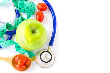 Green apple,red tomatos, measuring tape and stethoscope on white background