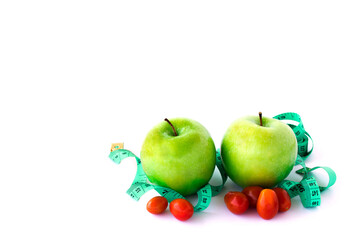 Fresh green apple and red tometos with measuring tape on white background.