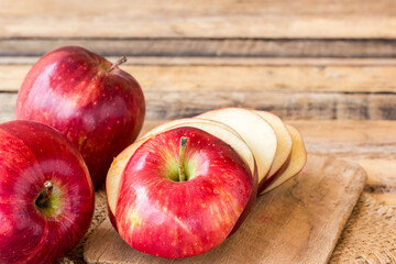 Naklejka na ściany i meble Fresh red apple on old wooden table background