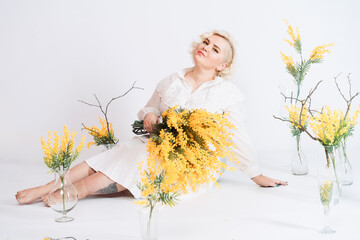 Girl in a white dress with flowers on a white background