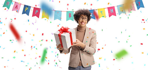 Cheerful young man celebrating birthday and holding a gift box