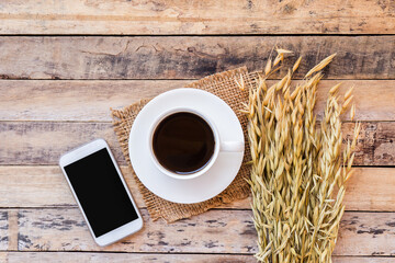 Coffee,wheat and smart phone on the old wooden table background