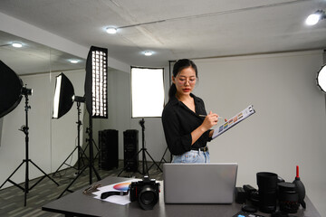 Attractive stylish woman using laptop in her modern photo studio. Creative career Concept