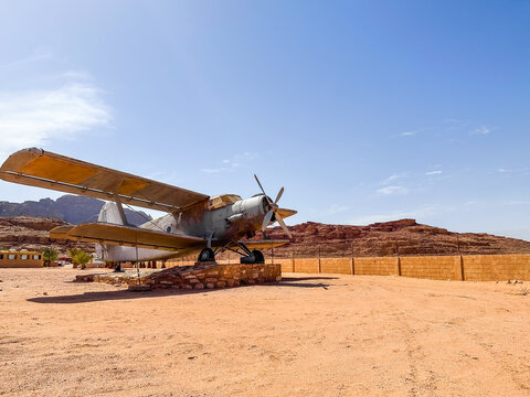 Amazing Shot of an Old Vintage Plane in the middle of the desert under the blue sky and shiny sun. Unique desert landscape