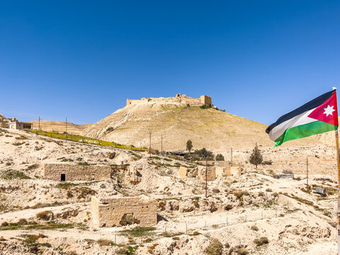 Jordanian flag next to Al Kerak Castle in Jordan. large medieval fortress. Crusader Historical castle