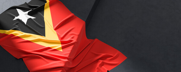 Flag of East Timor. Fabric textured East Timor flag isolated on dark background. 3D illustration - 765525813