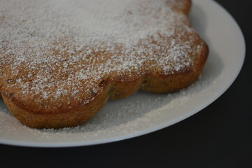 Kitchen, delicious, unusual homemade cake made of banana in the shape of a flower and placed on a white plate.