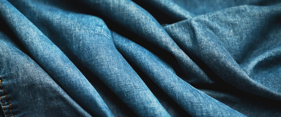 Texture of blue jeans with folds and bends. Background. Panorama. Banner.