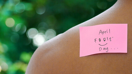 Note with text Happy Fools Day stuck to man's back