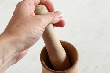 Hand holds pestle of mortar