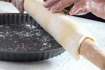 Chef unroll dough sheet over baking tin. Making Treacle Pie Series.