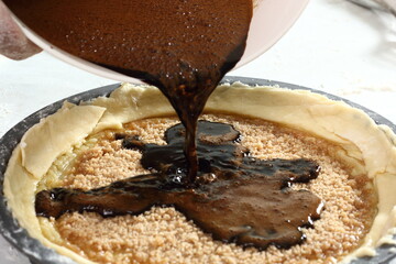 Pouring molasses and eggs mixture into pastry case. Making Treacle Pie Series.